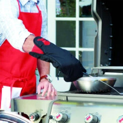 Weber Grills Black With Red Kettle Cotton Grill Glove With Extra Long Cuff -BBQ Haven Shop Weber Black with red kettle cotton grill glove resting in use