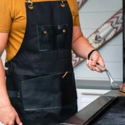 The Apres Supply Co. The Premium Grill Master BBQ Apron - Waxed Recycled Cotton With Leather Trim -BBQ Haven Shop apres supply co premium grillmaster lifestyle